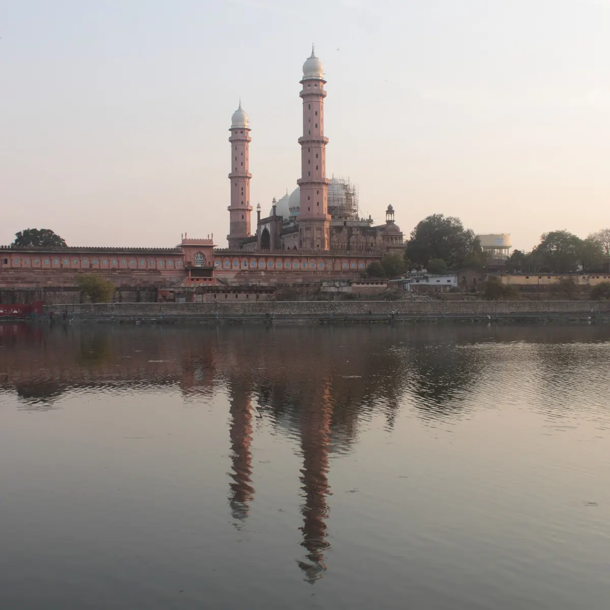 Taj-ul-Masajid and its minarets reflected across a lake in Bhopal